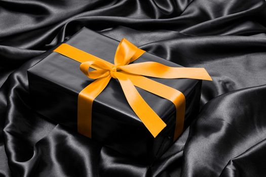 Black gift box with yellow satin ribbon and bow