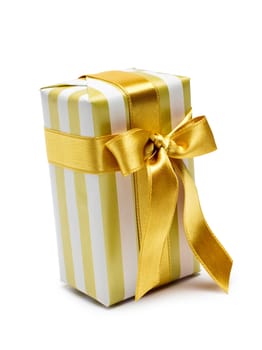 Gift box in gold duo tone with golden satin ribbon and bow isolated over white background.