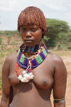 TURMI, ETHIOPIA - NOVEMBER 19, 2014: Young Hamer girl with necklace and traditional hairstyle on November 19, 2014 in Turmi, Ethiopia.