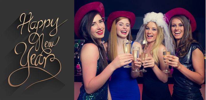 Laughing friends clinking champagne glasses at a hen night against classy new year greeting