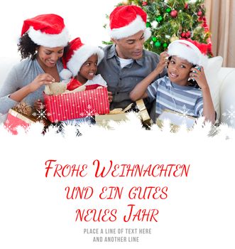 Happy family playing with Christmas presents against frohe weihnachten message
