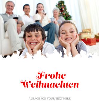 Brother and sister on floor with their family in Christmas against christmas greeting in german