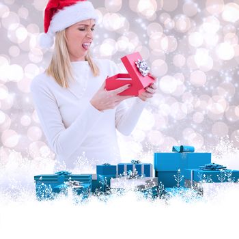 Disappointed blonde opening christmas gift against light glowing dots design pattern
