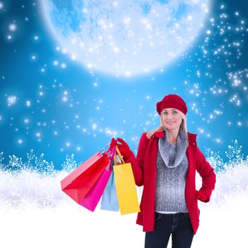 Blonde in winter clothes holding shopping bags against blue background with vignette