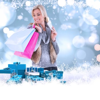 Blonde in winter clothes holding shopping bags against white glowing dots on blue
