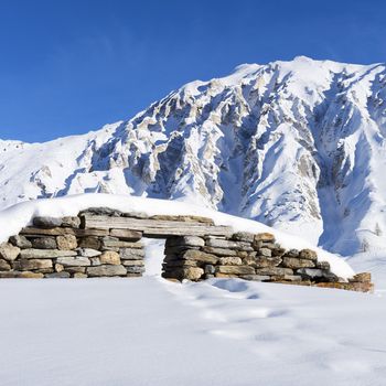 view of ruins under snow in french alps.