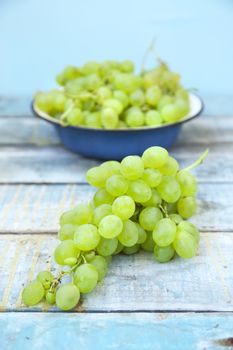 branches of fresh green grape on a wooden surface