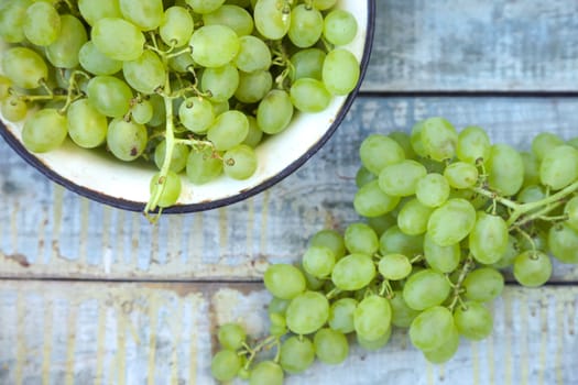 branches of fresh green grape on a wooden surface