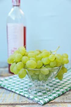 branches of fresh green grape on a wooden surface