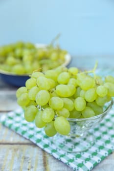 branches of fresh green grape on a wooden surface