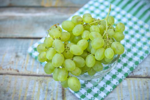 branches of fresh green grape on a wooden surface