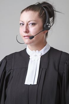 Woman in her thirties, wearing canadian lawyer toga and a phone headset