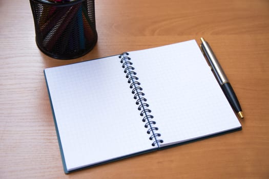 paper notebook with pen on wooden background