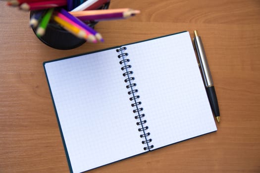 paper notebook with pen on wooden background