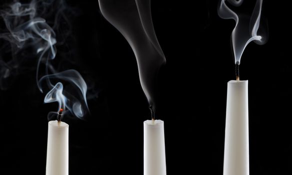 extinguished candle with smoke, isolated over black
