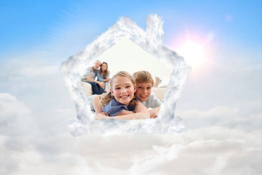 Happy siblings posing on a carpet with their parents on the background against blue sky with white clouds