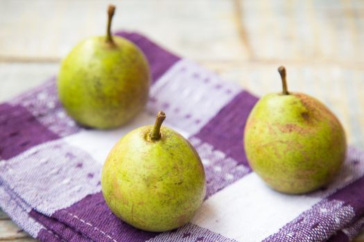  few fresh ripe pears are on a wooden surface