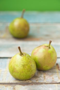 few fresh ripe pears are on a wooden surface