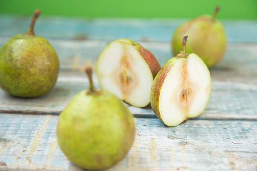 few fresh ripe pears are on a wooden surface