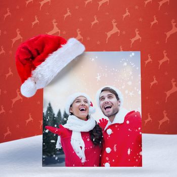 festive young couple against orange reindeer pattern