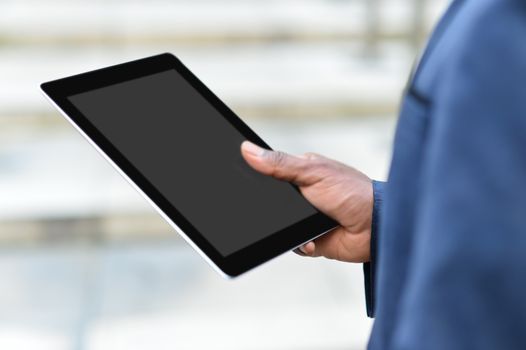 Businessman in outdoors holding a tablet device