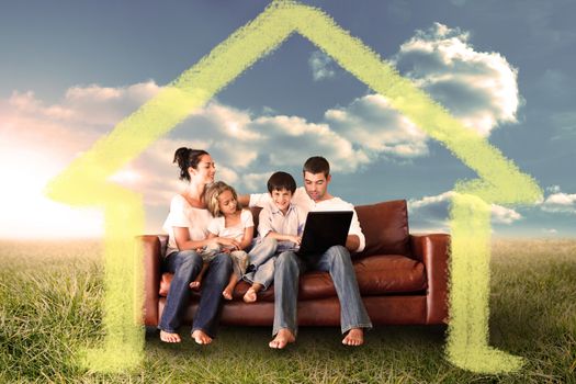 Happy family using the laptop in a field against house outline