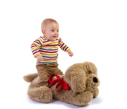 baby boy jump over plush dog on white background