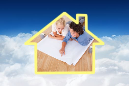 Young man showing a point on a plan to his fiance against bright blue sky over clouds