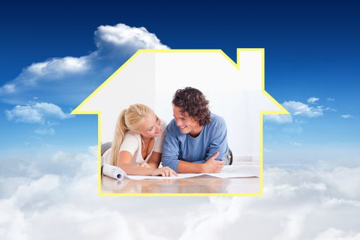 Smiling couple moving in a new house against bright blue sky with clouds