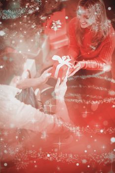 Sitting couple giving each other presents against glittering christmas tree design