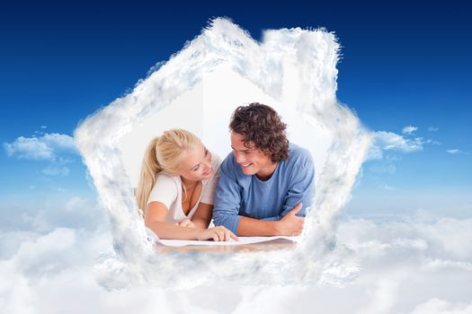 Smiling couple moving in a new house against bright blue sky over clouds