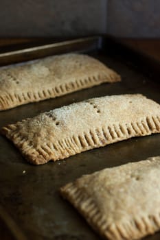 Whole wheat toaster pastries, lightly dusted with sugar crystals and filled with raspberry filling.