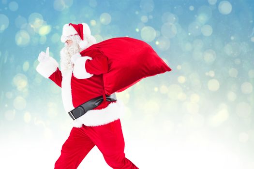 Positive santa with a sack and thumbs up against blue abstract light spot design