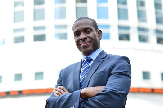 African businessman with arms crossed at the outdoors