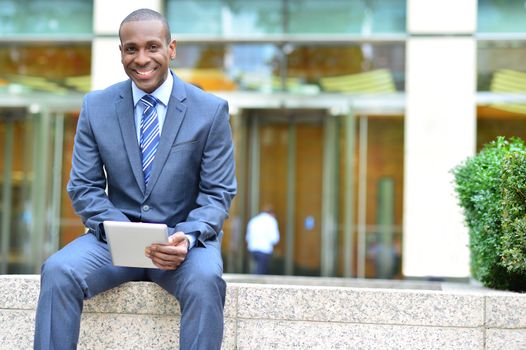 Businessman using his digital tablet at outdoors