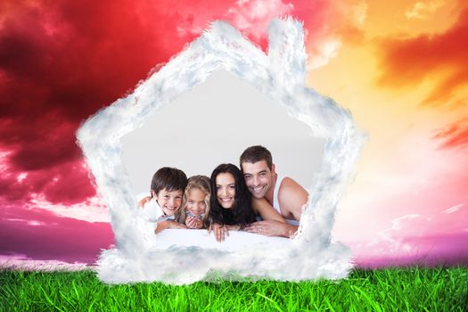 Lovely family lying on their bed against green grass under red and purple sky