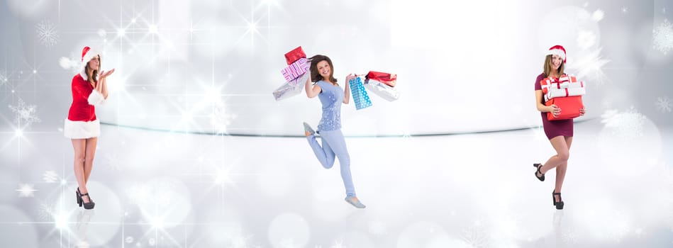 Festive brunette holding pile of gifts against snowflakes in room