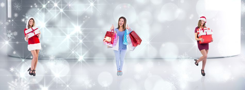 Festive brunette holding pile of gifts against lights twinkling in modern room