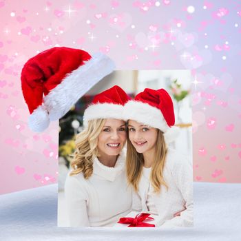 Festive mother and daughter smiling at camera against digitally generated girly heart design