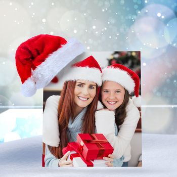 Festive mother and daughter smiling at camera against lights twinkling in room