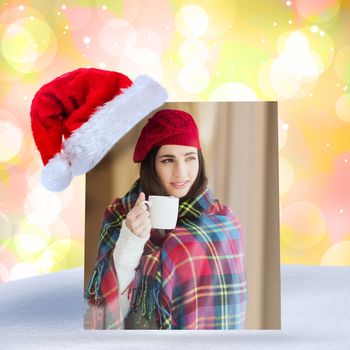 Brunette with cover holding mug and thinking against girly pink and yellow pattern