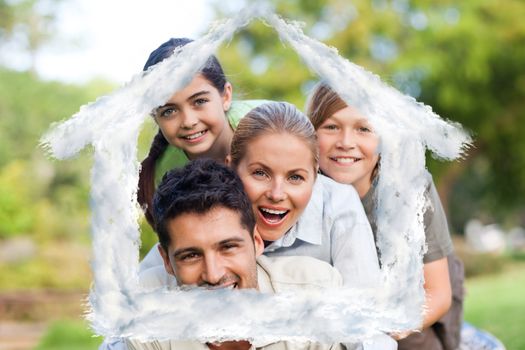 Happy family in the park against house outline in clouds