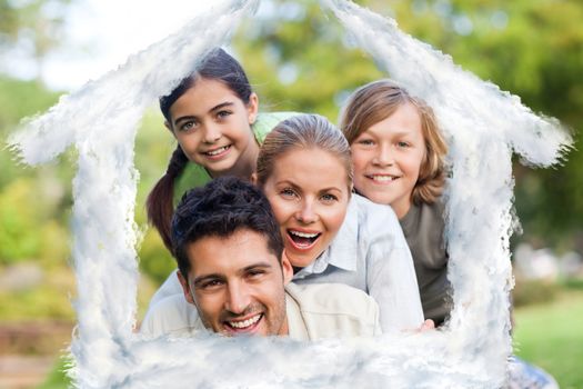 Happy family in the park against house outline in clouds