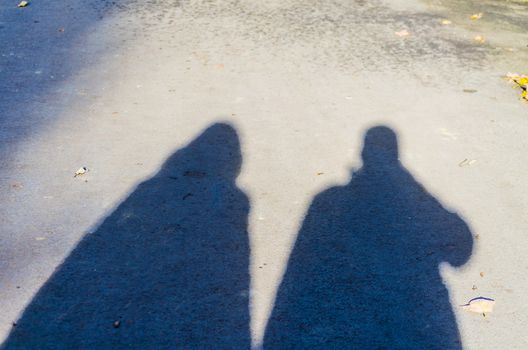 Shadow play, shadow of a couple during a walk.