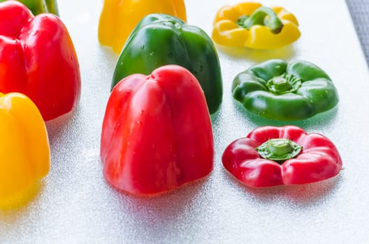 Yellow, Red, Green Bell Pepper cut on a silver platter.