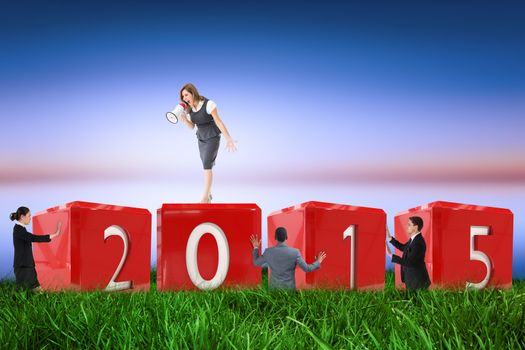 Businesswoman shouting through megaphone against green grass under blue and purple sky