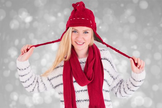 Festive blonde smiling at camera against grey abstract light spot design