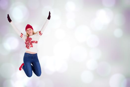 Festive blonde in christmas jumper against purple abstract light spot design