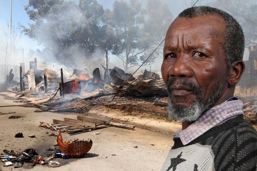African man with worried expression at scene of fire and arson