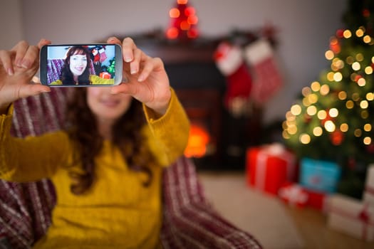 Beauty redhead taking a selfie at christmas at home in the living room